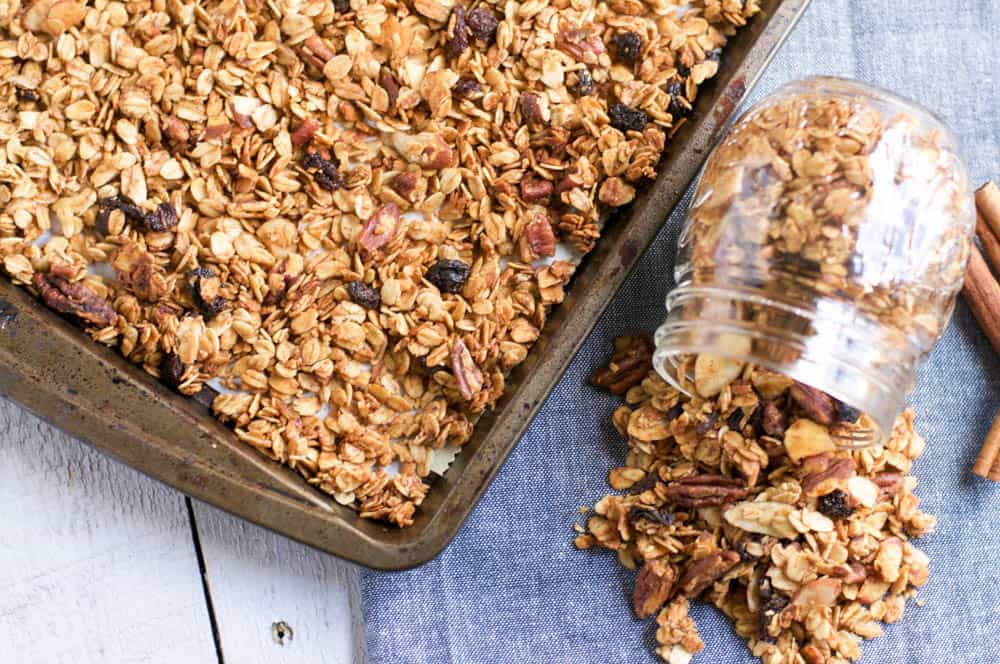 Maple Pecan Granola on pan with jar beside it.