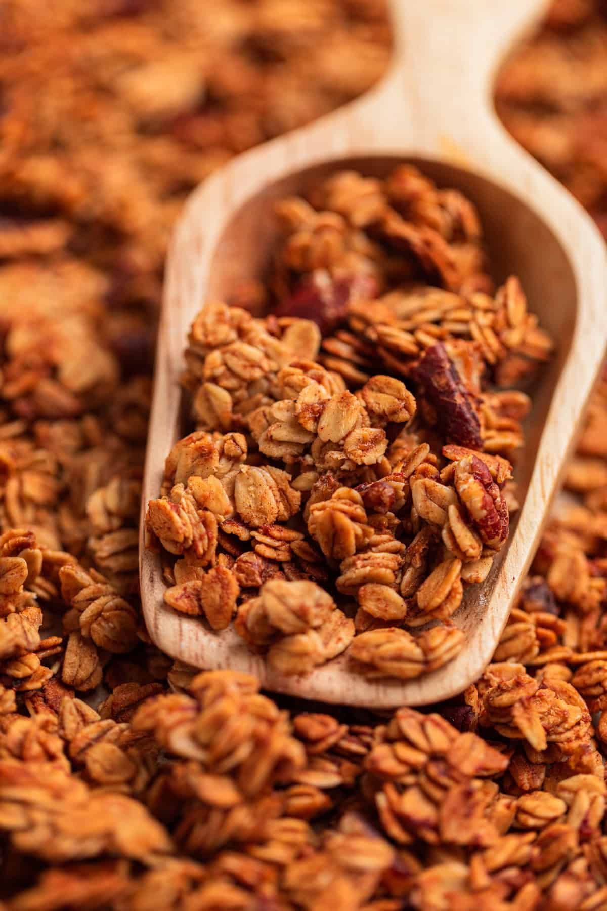 Banana bread granola in scoop on baking sheet.