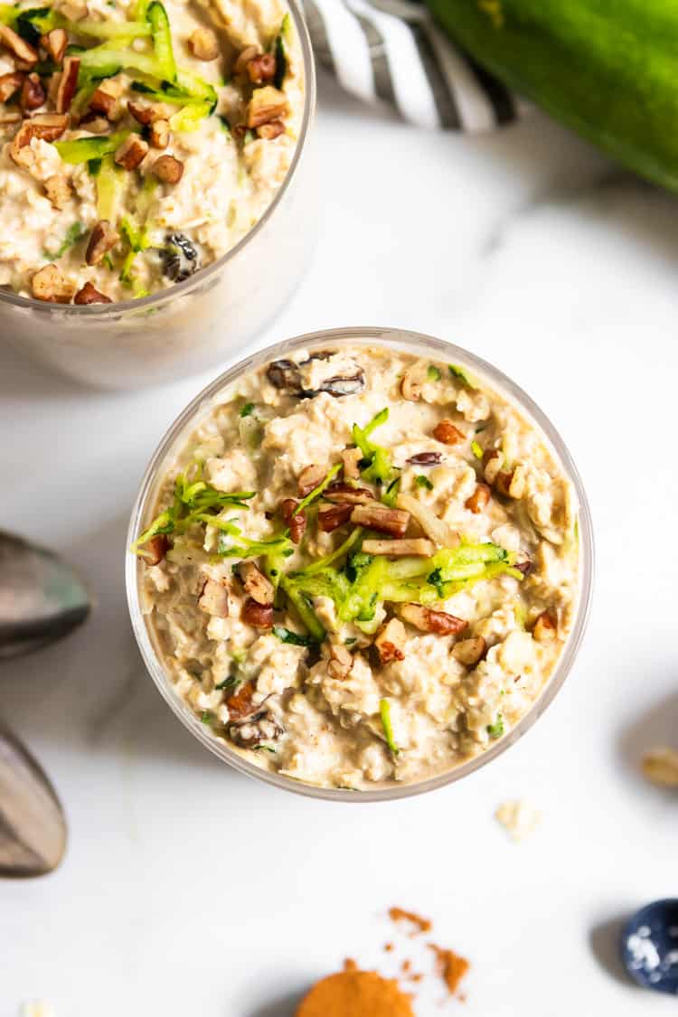 Zucchini overnight oats in jar with pecans and shredded zucchini on top.
