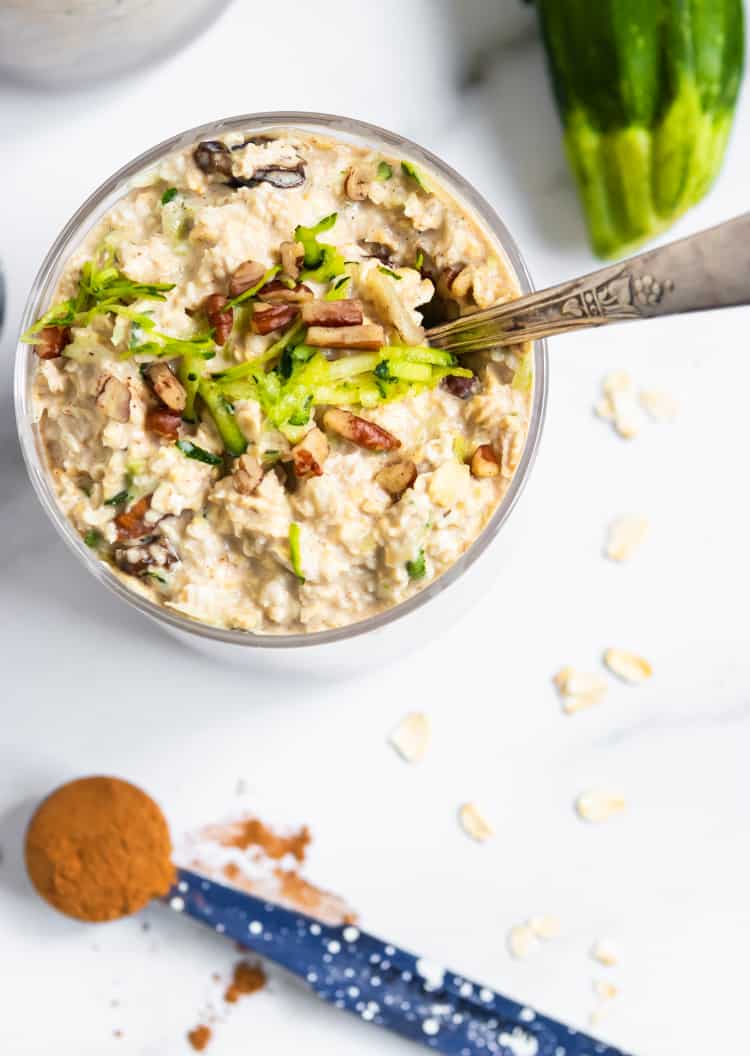 Overhead view of overnight oats with shredded zucchini and chopped pecans on top.