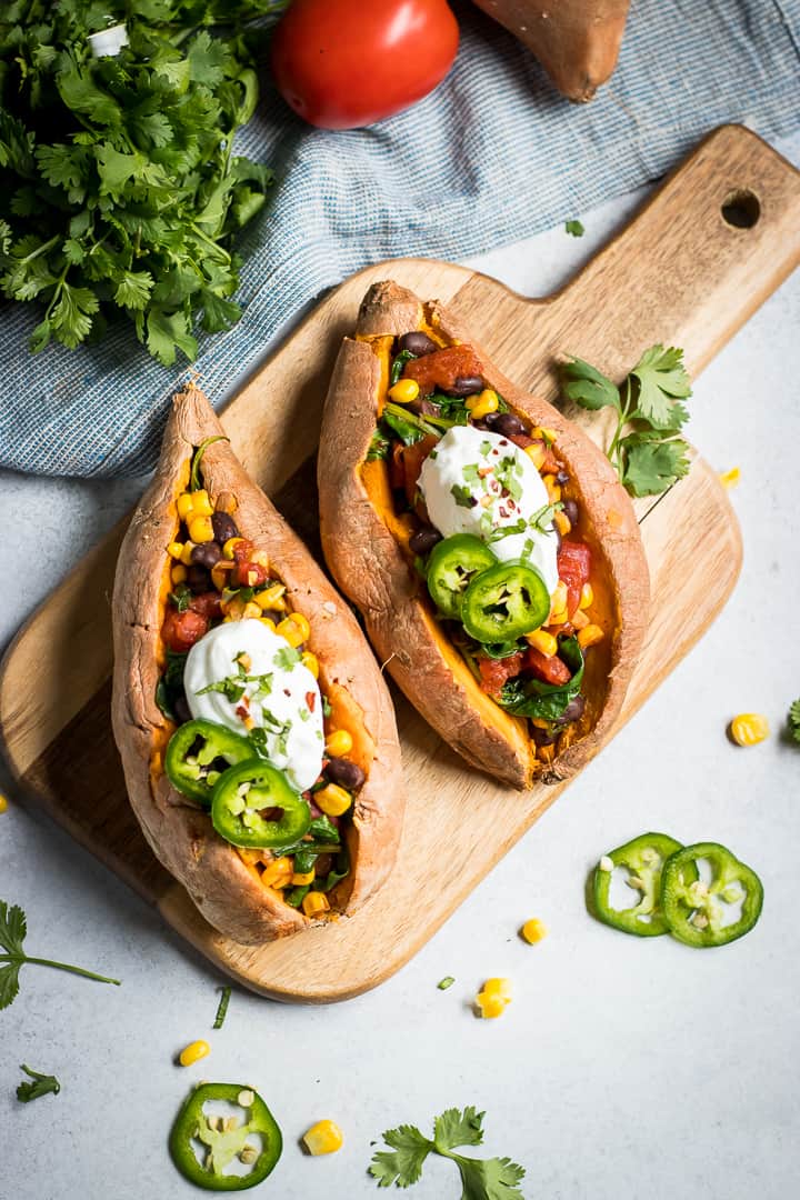 Mexican stuffed sweet potatoes with sour cream and jalapeno on top.