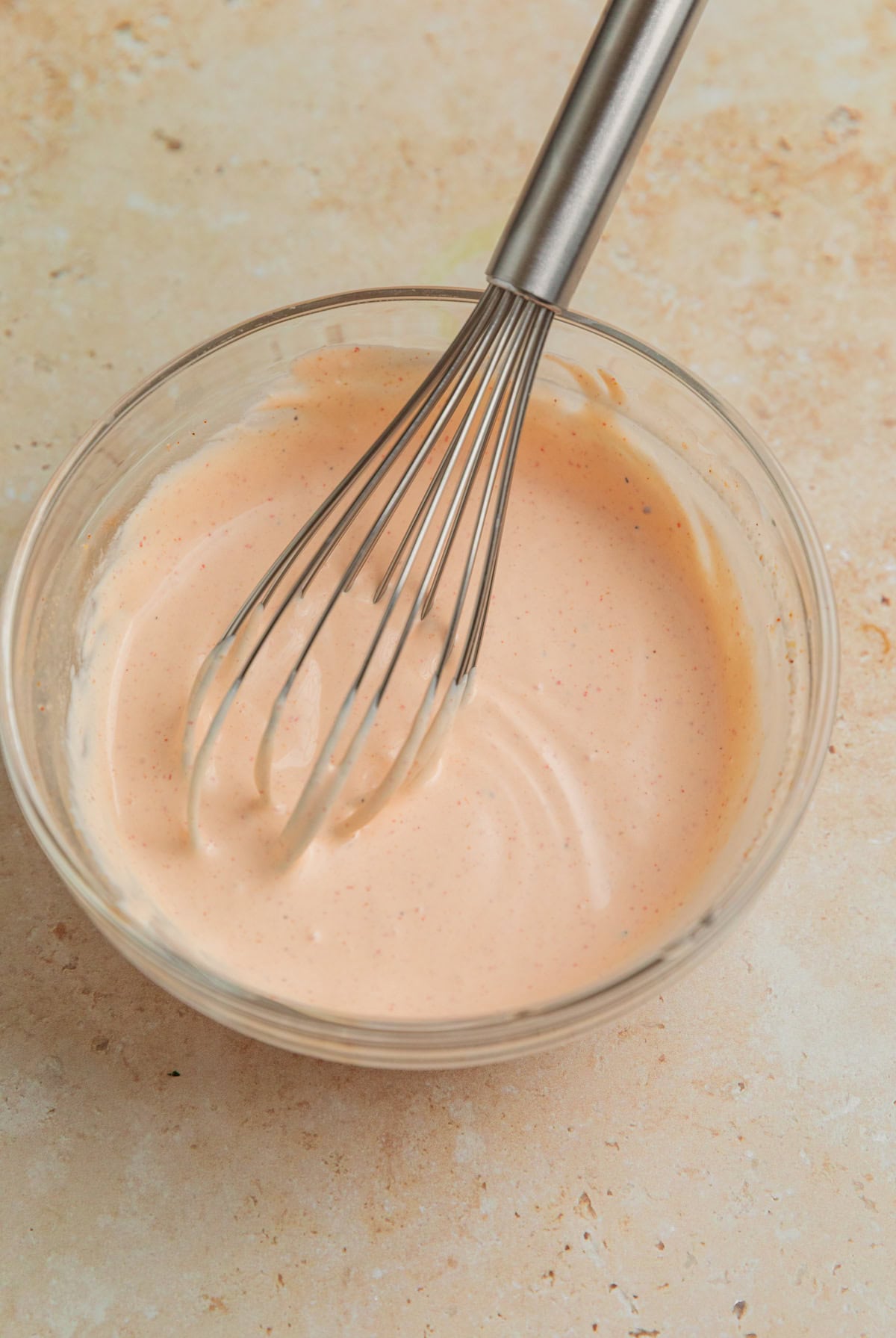 Chipotle crema sauce in bowl with whisk.