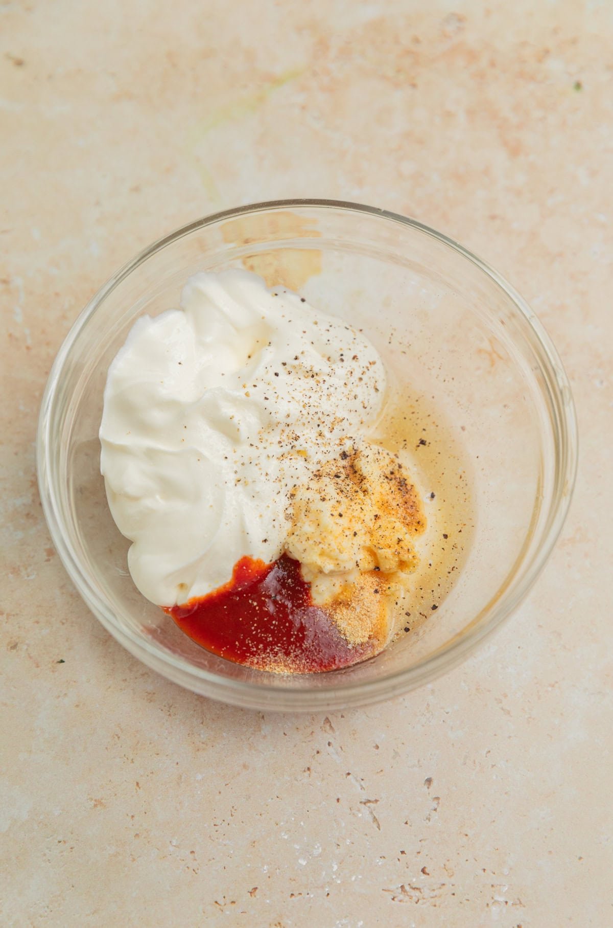 Sour cream, mayonnaise, garlic, lime juice, adobo sauce and other ingredients in bowl.