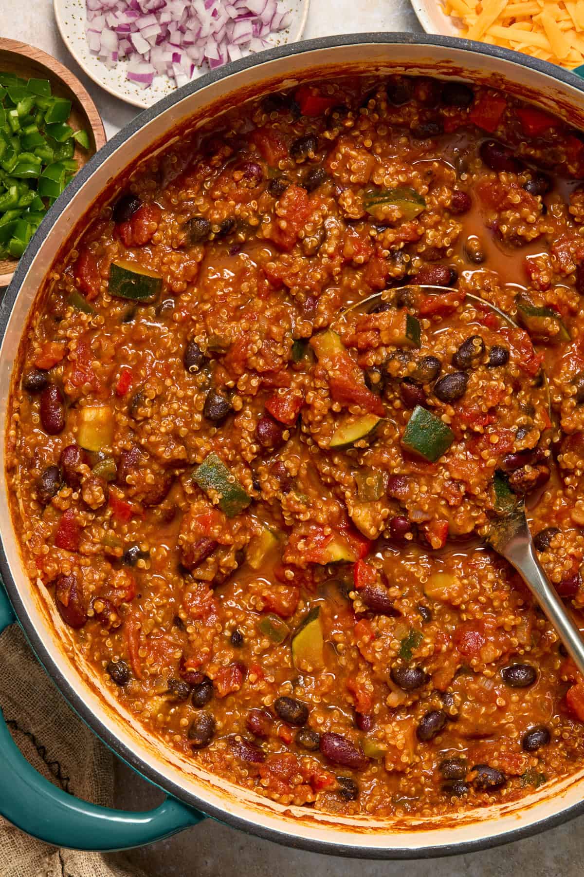 Pot with pumpkin quinoa chili with ladle.