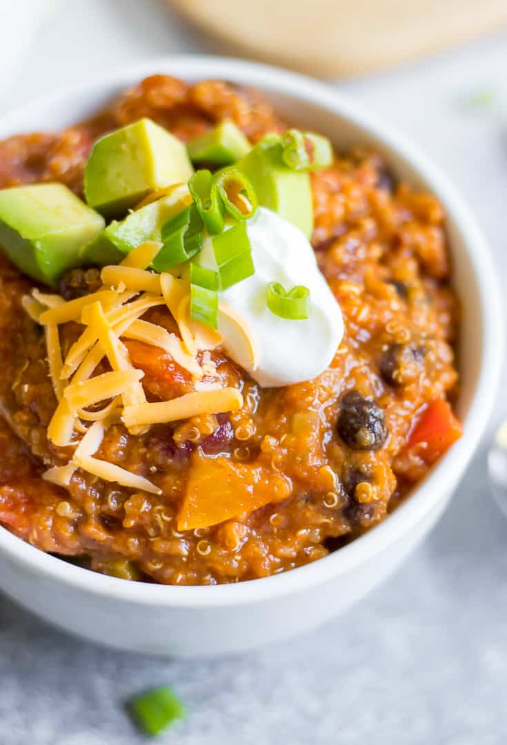 Pumpkin Quinoa Chili in white bowl with toppiongs.