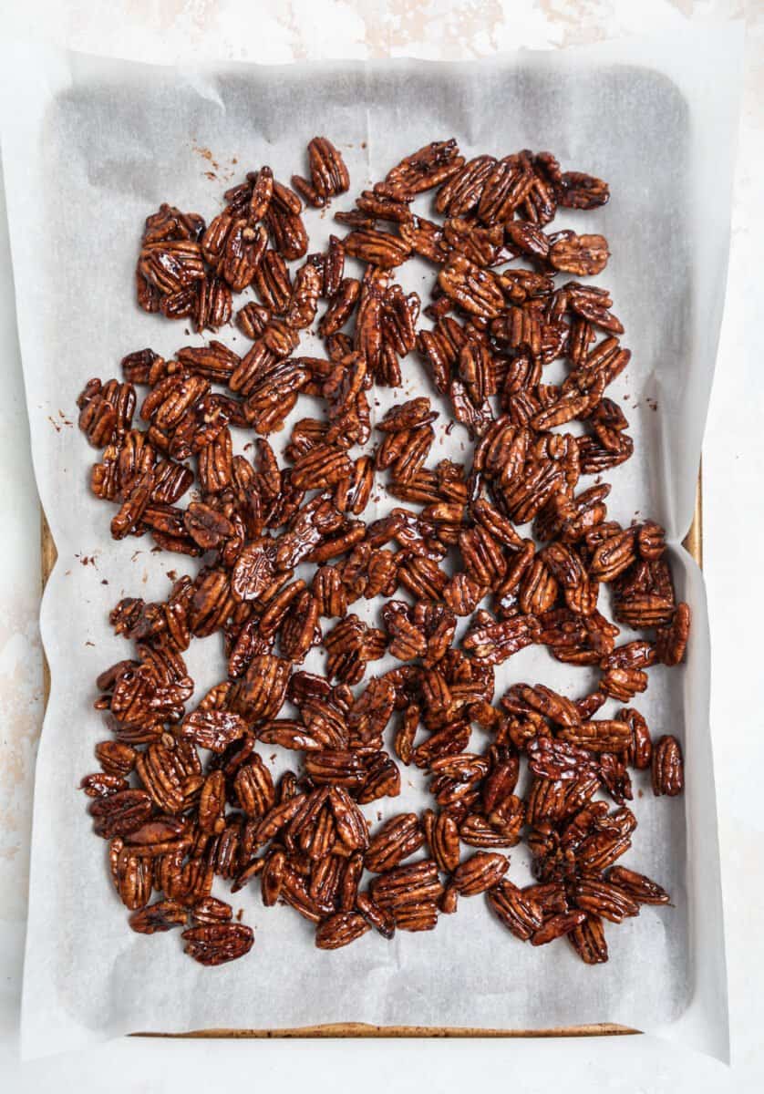 Lined cookie sheet with cooling maple pecans.
