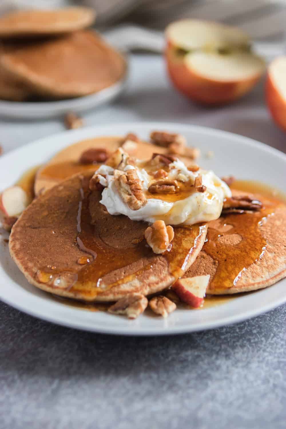 Apple Oatmeal Pancakes with maple syrup, yogurt and pecans.