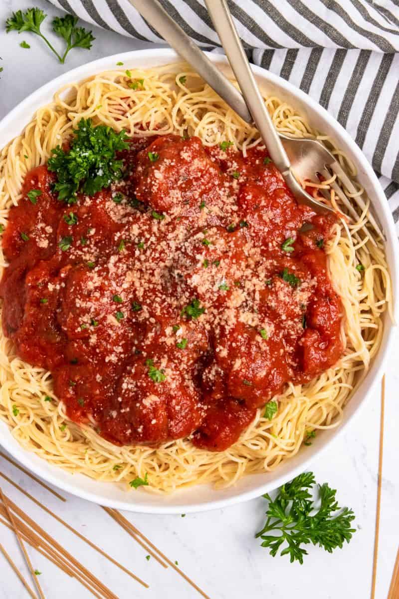 Overhead shot of spaghetti in bowl with meatballs with zucchini in marinara.