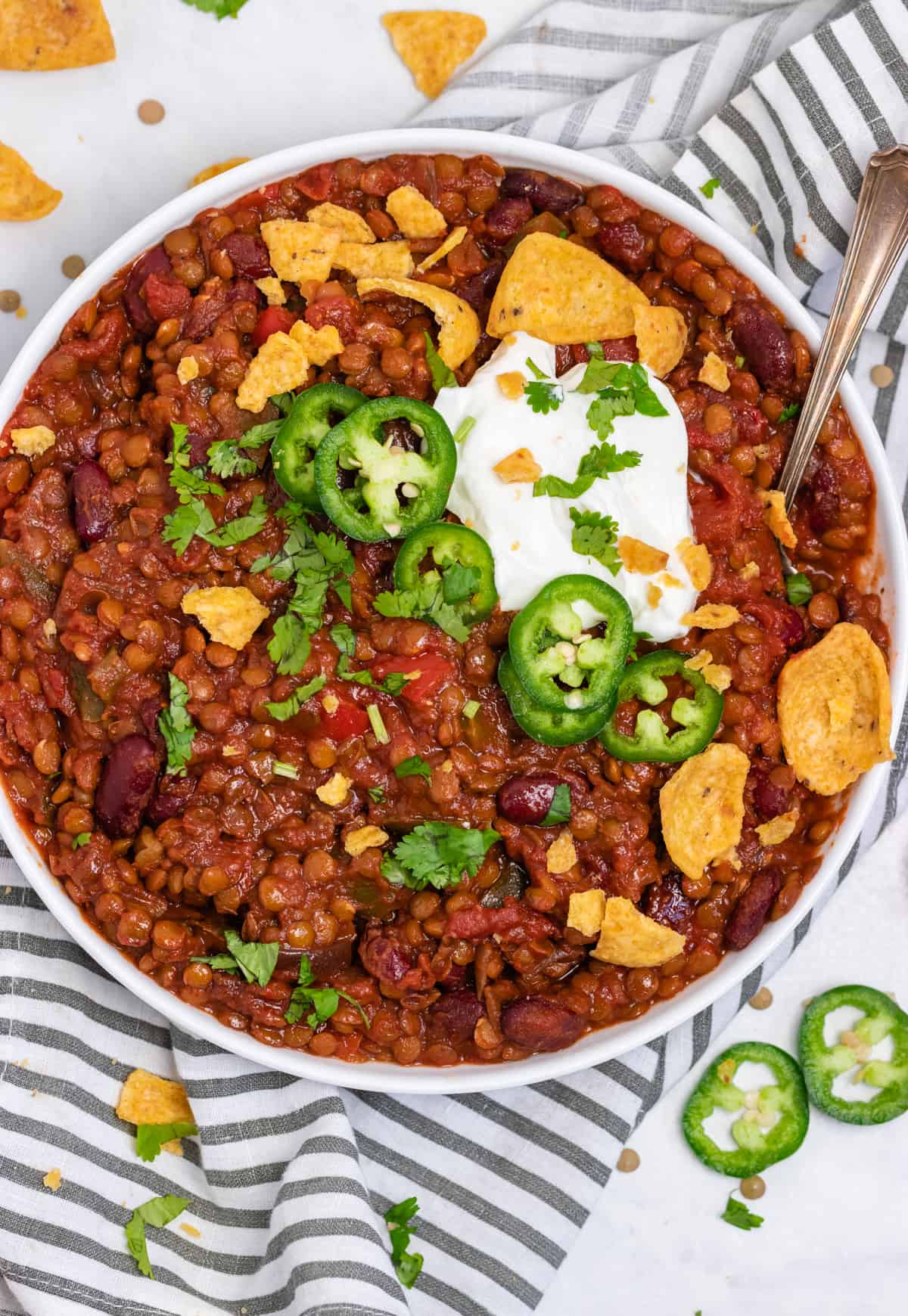 Overhead view of crock pot lentil chili in white bowl.