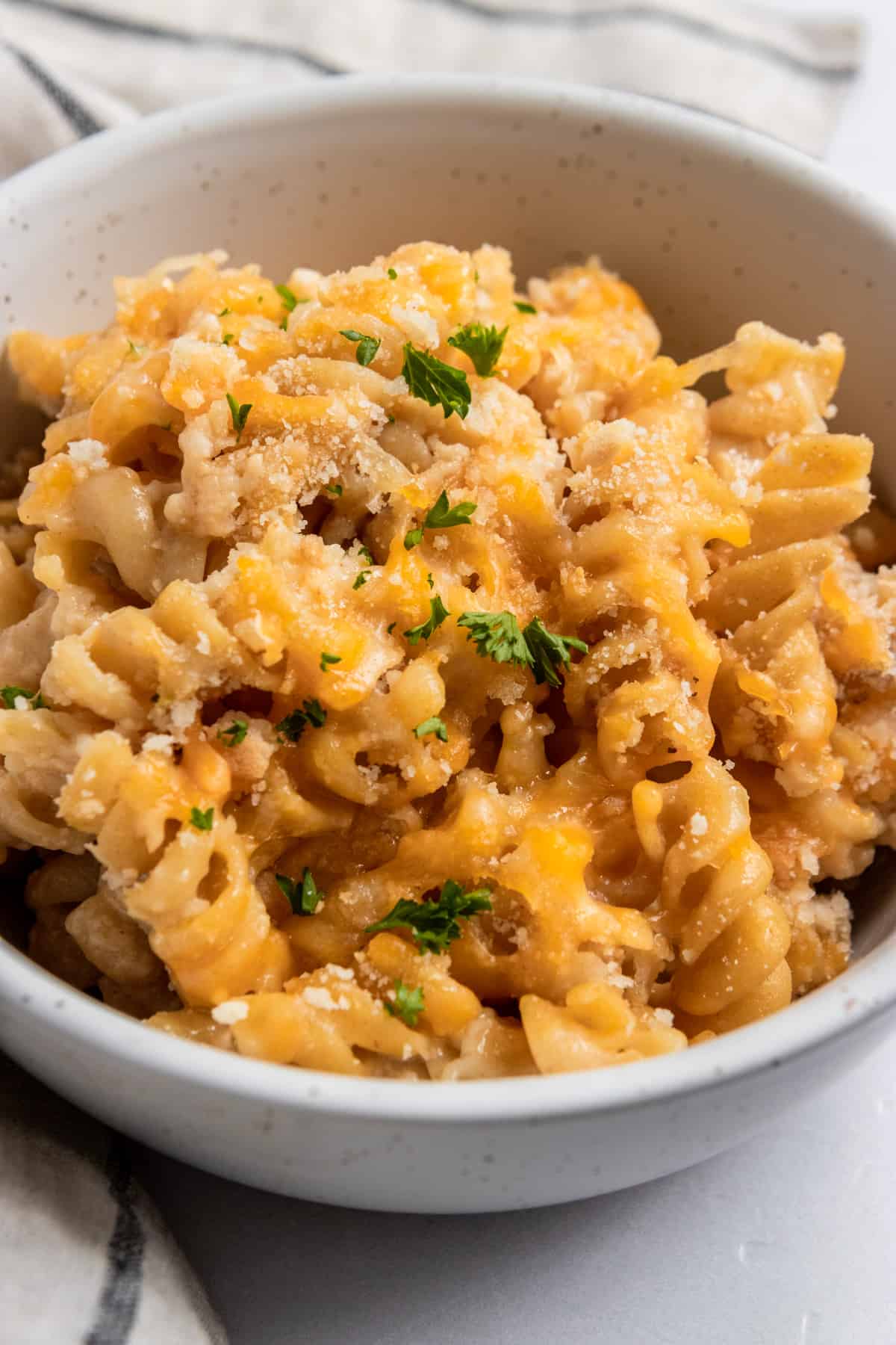 Bowl of protein macaroni and cheese with breadcrumbs and parsley.