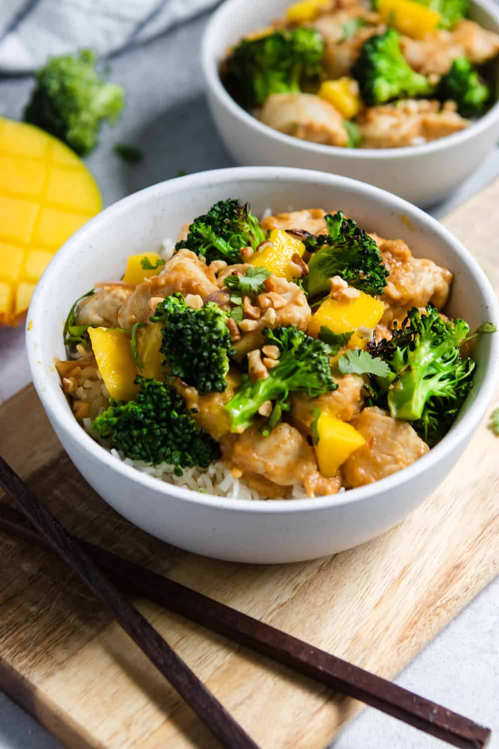 Bowl of stir fry with broccoli, mango and chicken.