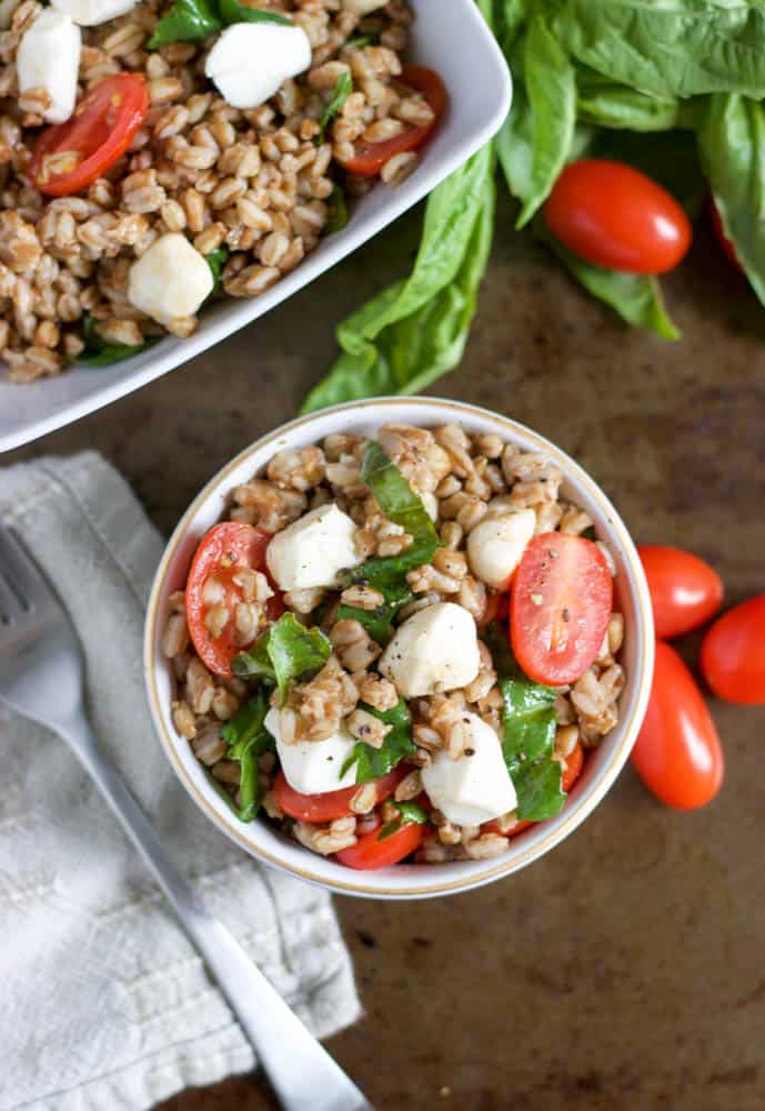 Overhead shot of Caprese Farro Salad with serving dish beside.