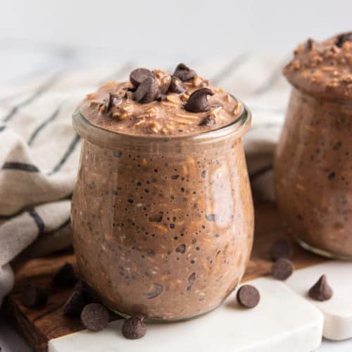 Jar of chocolate overnight oats topped with chocolate chips.
