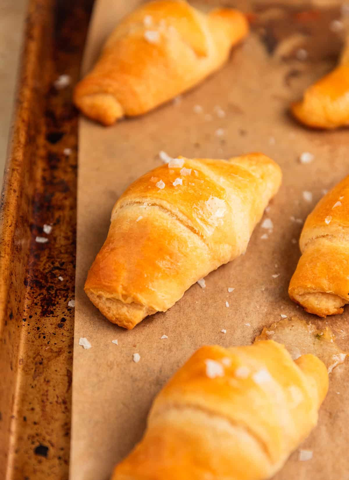 Butter topped crescent rolls on pan.