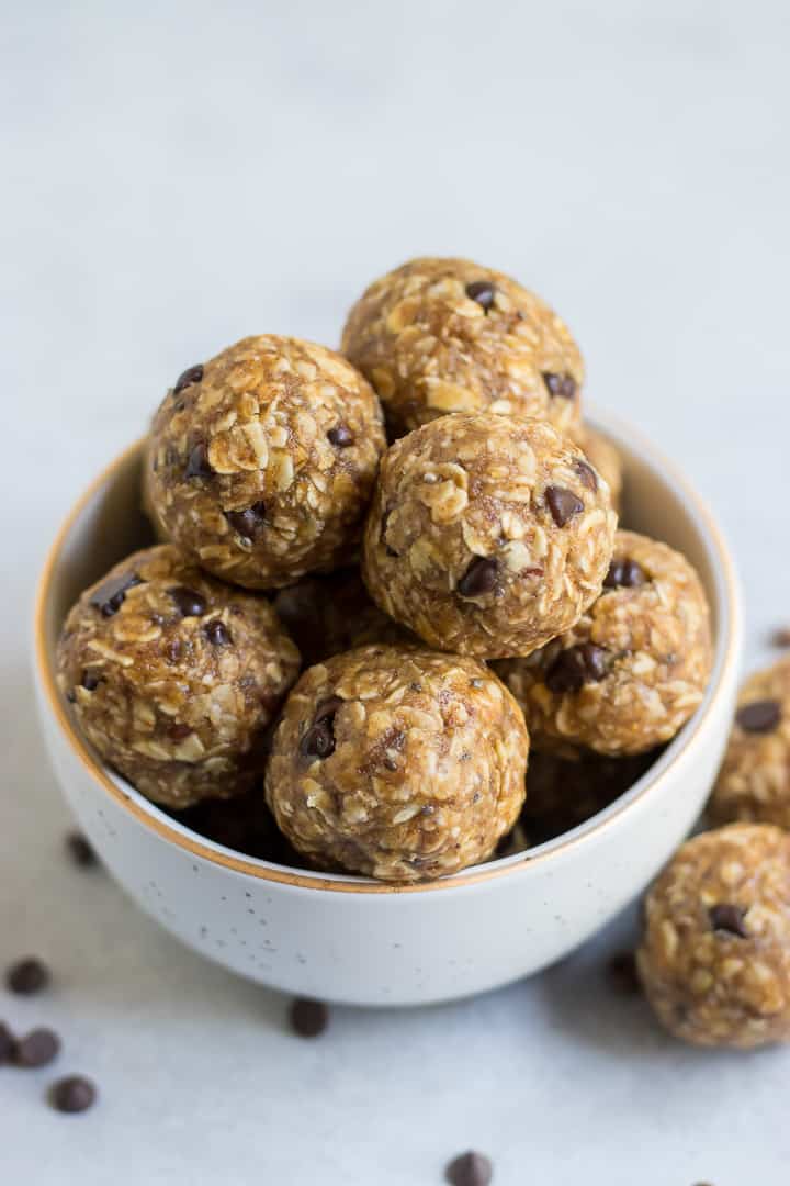 Oatmeal balls with chocolate chips in white bowl with gold trim.