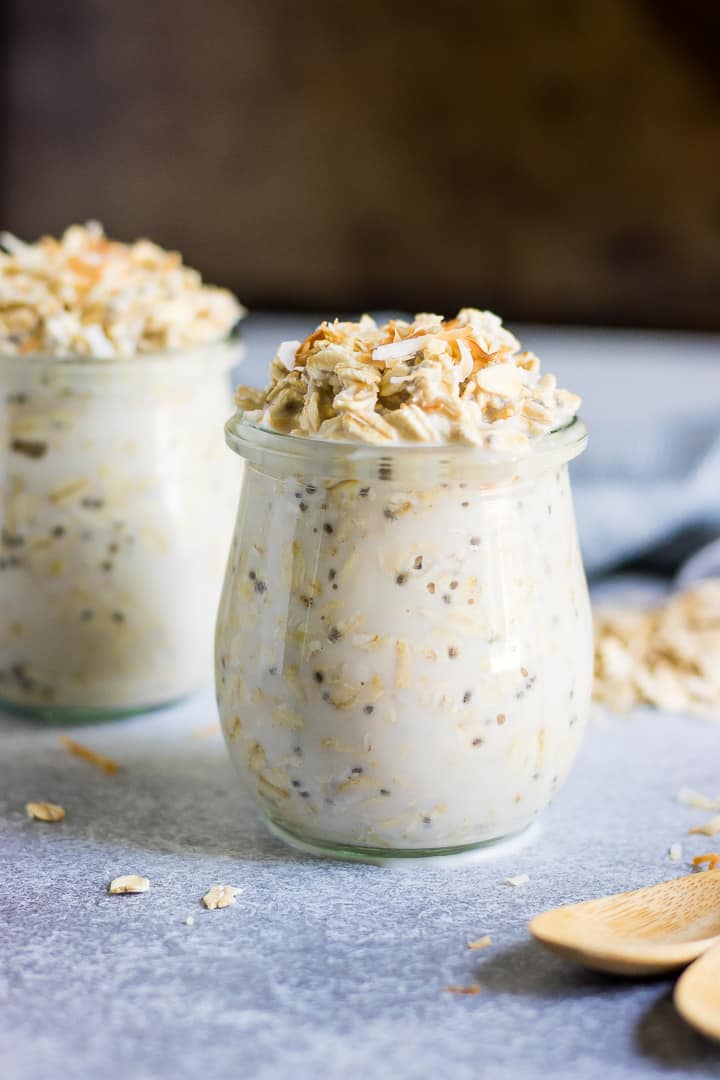 Two jars of coconut oats with toasted coconut on top.