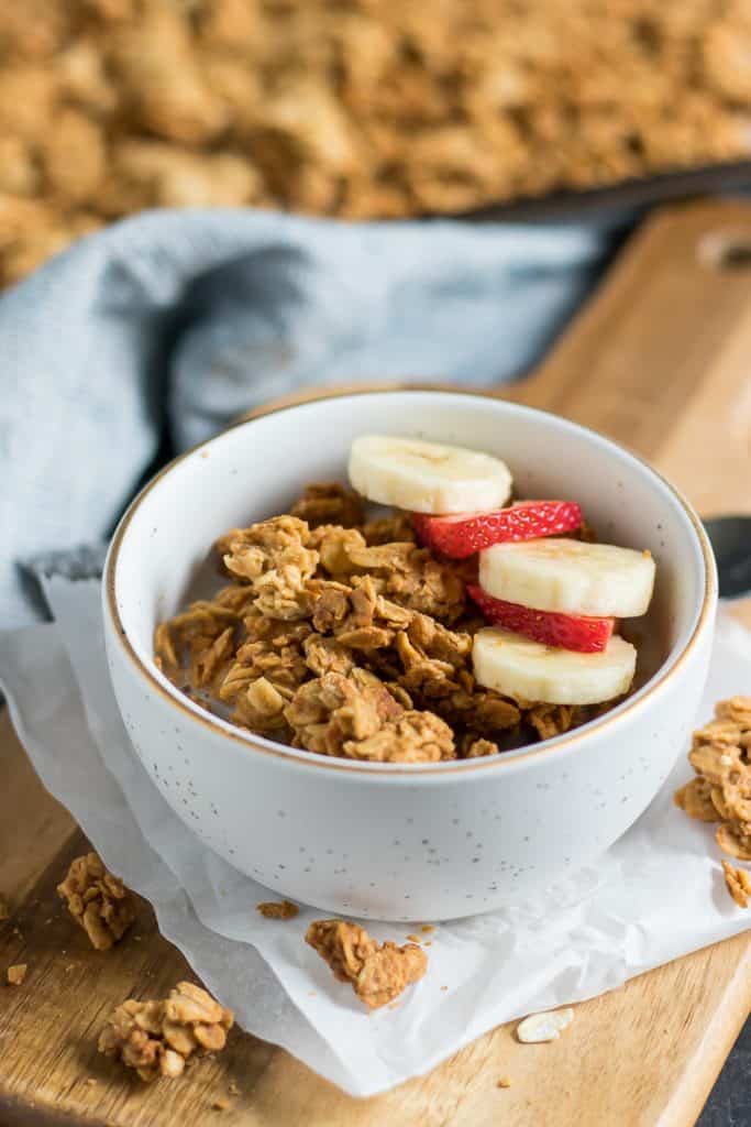 Peanut Butter Granola in bowl with banana and strawberry slices.