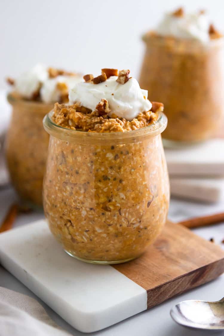 Pumpkin overnight oats in jar on coaster.