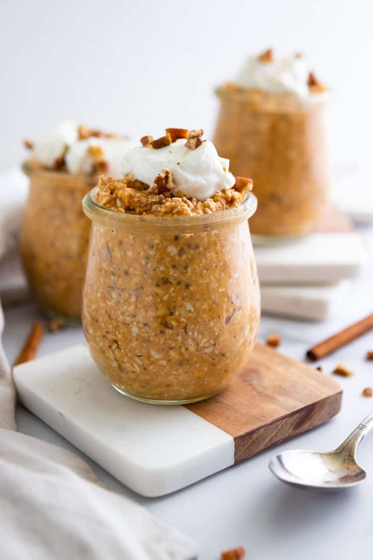 Jar of oatmeal with pumpkin, pecans and dollop of yogurt.