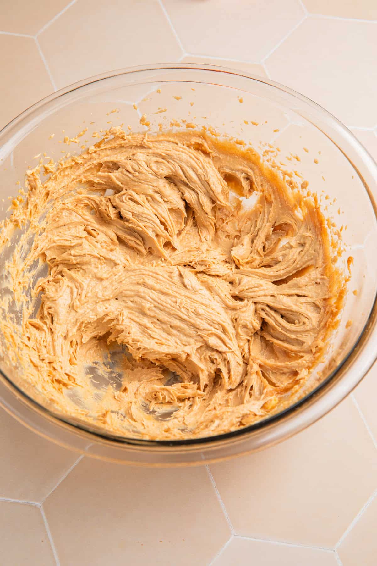 Creamed peanut butter, butter, sugars and vanilla in bowl.