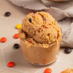Glass with edible peanut butter cookie dough scooped into it.