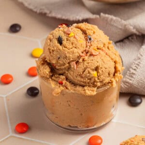 Glass with edible peanut butter cookie dough scooped into it.