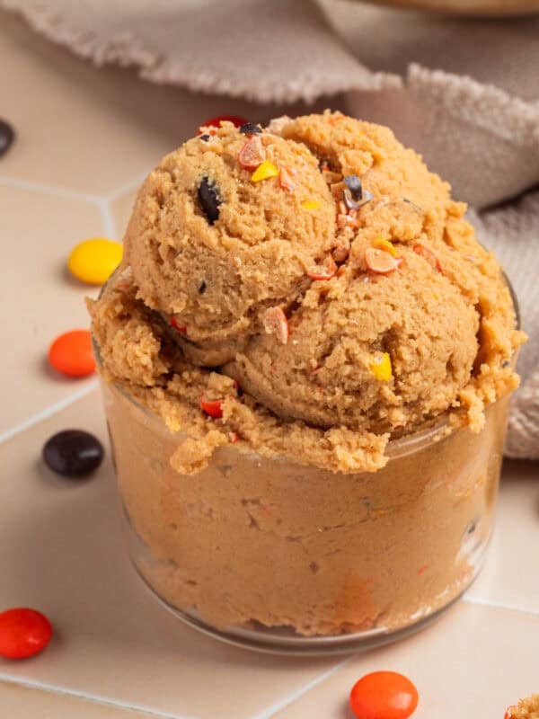 Glass with edible peanut butter cookie dough scooped into it.