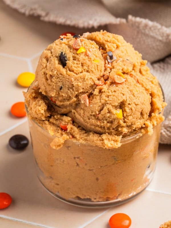 Glass with edible peanut butter cookie dough scooped into it.