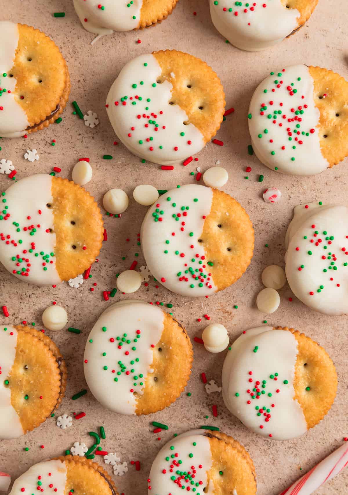 Christmas Ritz cracker cookies dipped in white chocolate and arranged on surface.
