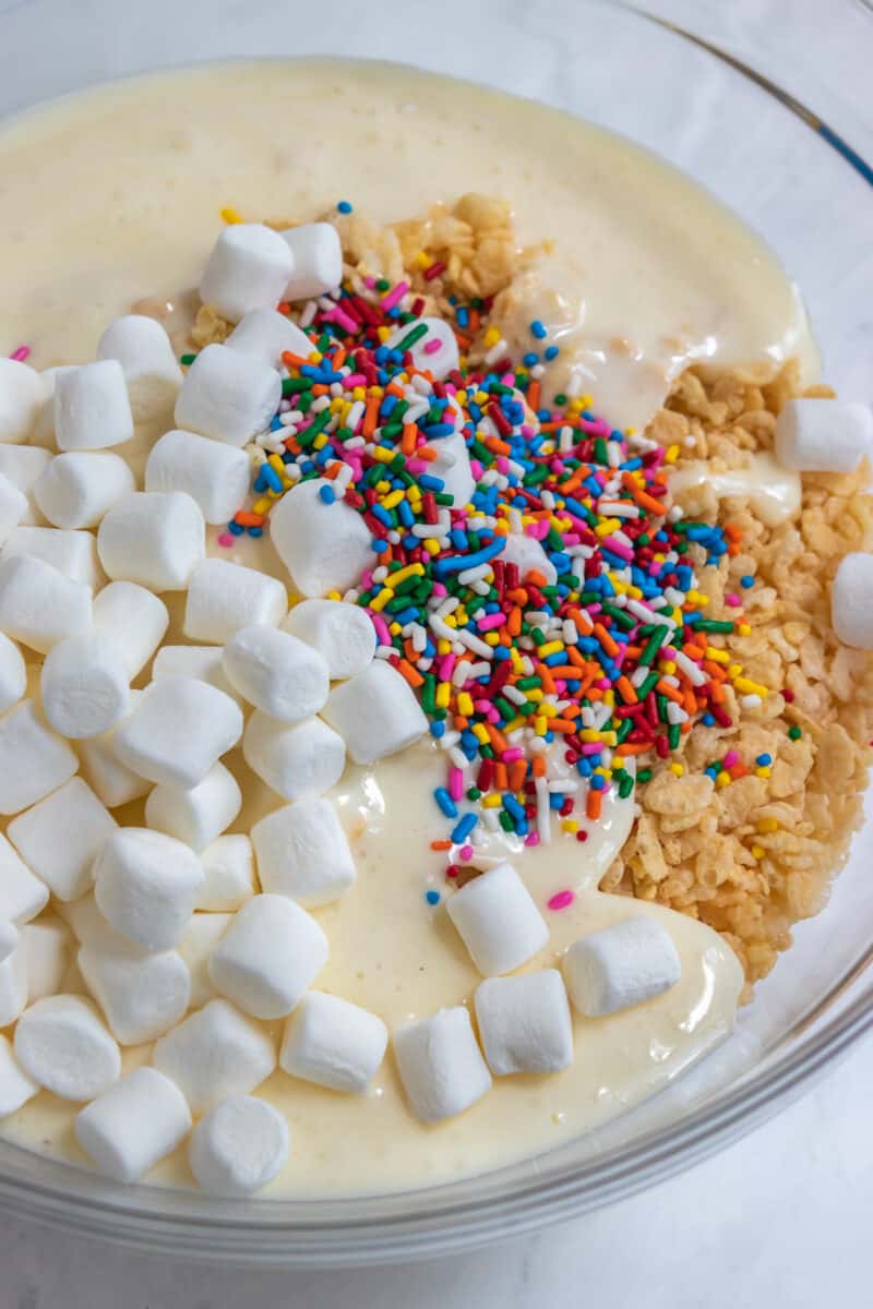 Marshmallows, sprinkles, rice krispies in mixing bowl.