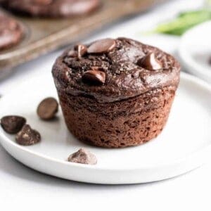 Green smoothie chocolate muffin on white plate.