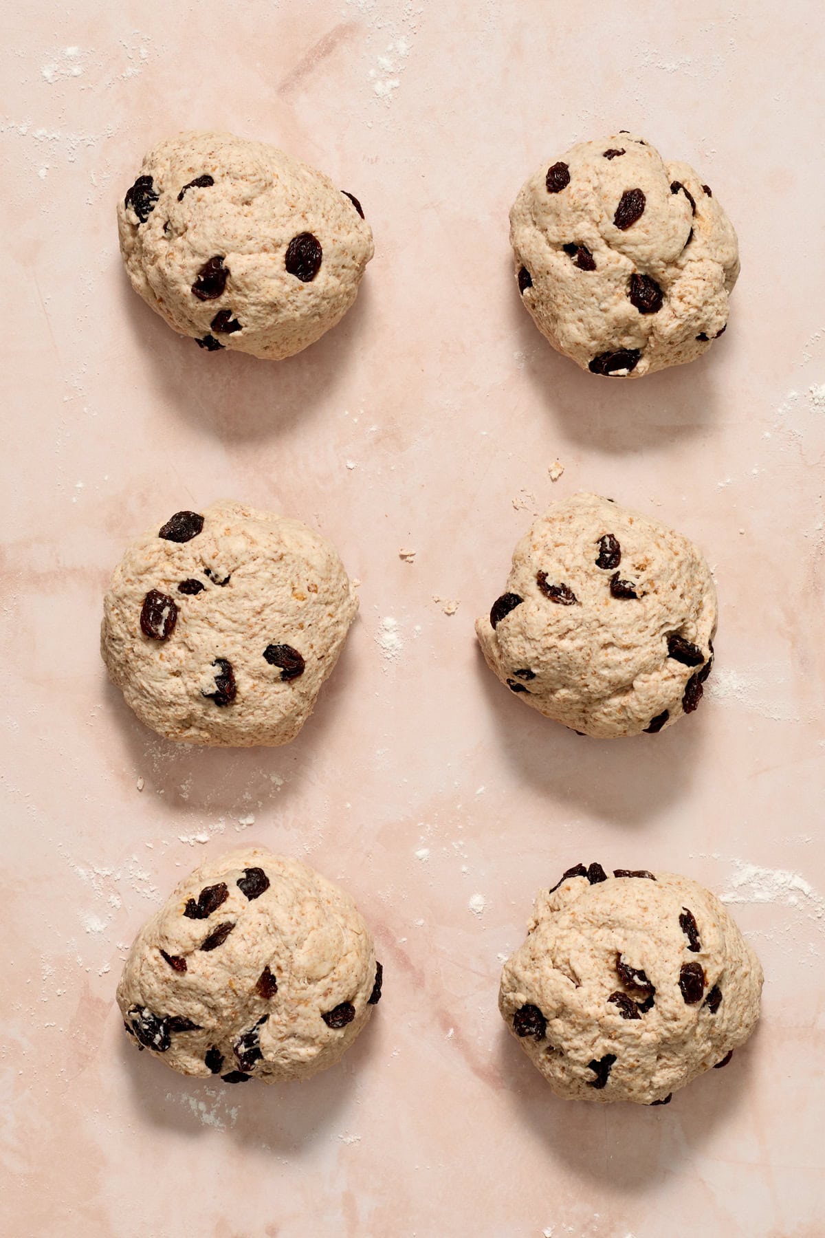 6 even balls of bagel dough arranged on surface.