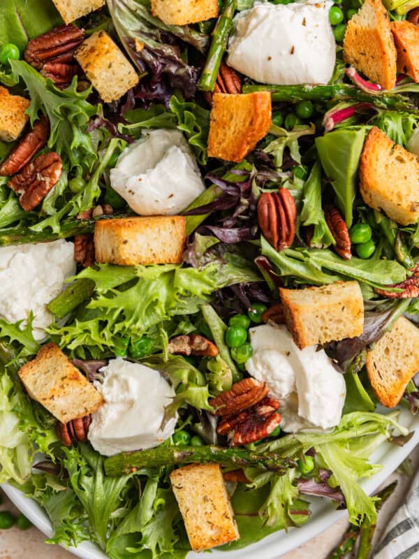 Spring green salad with asparagus, burrata, peas, homemade croutons, and pecans.