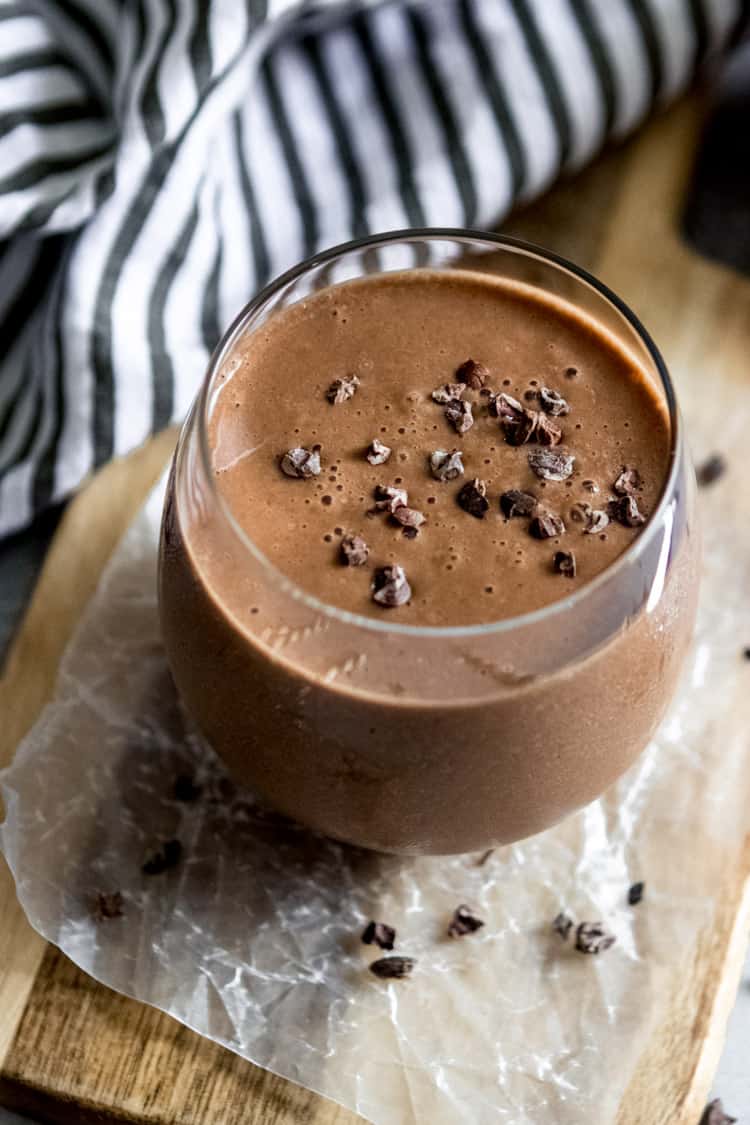 chocolate smoothie in glass with cacao nibs on top