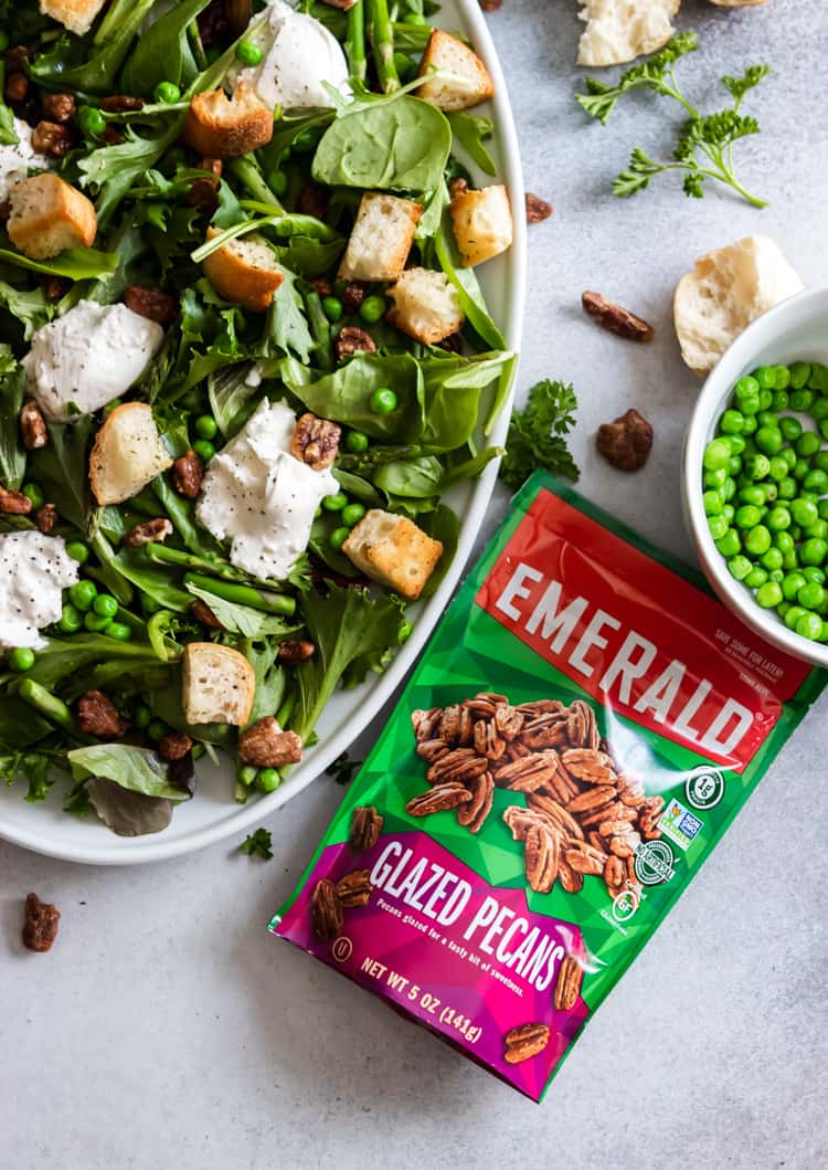 Spring green salad with package of Emerald pecans beside it.