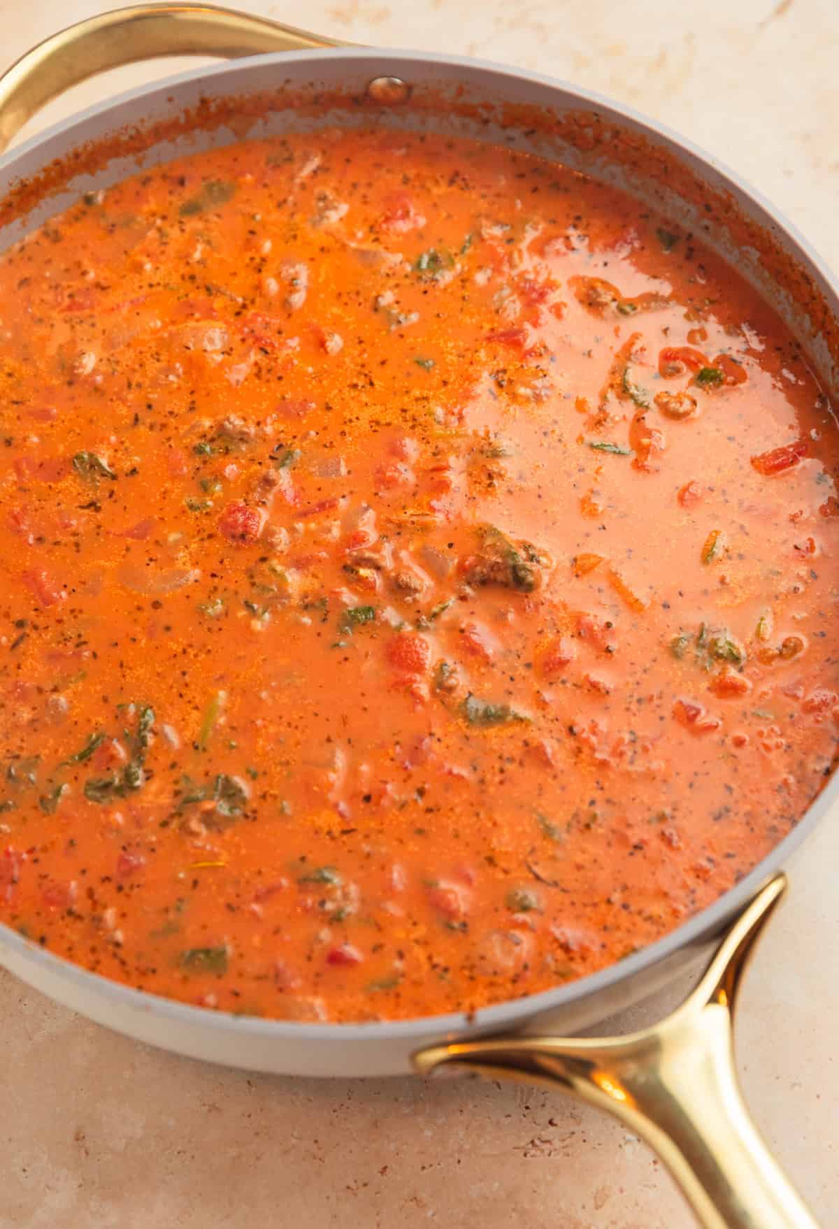 Creamy tomato sauce in pan with spinach.