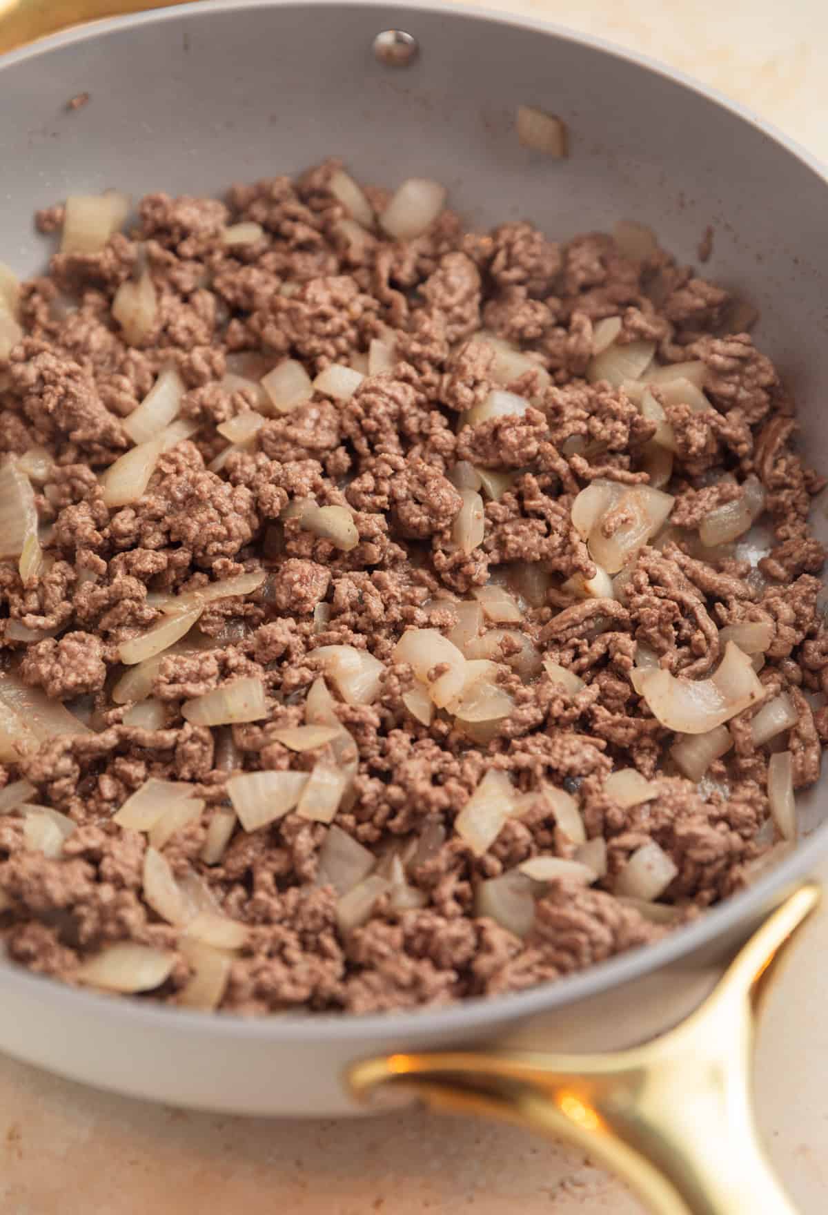 Ground beef browned in skillet with onions.