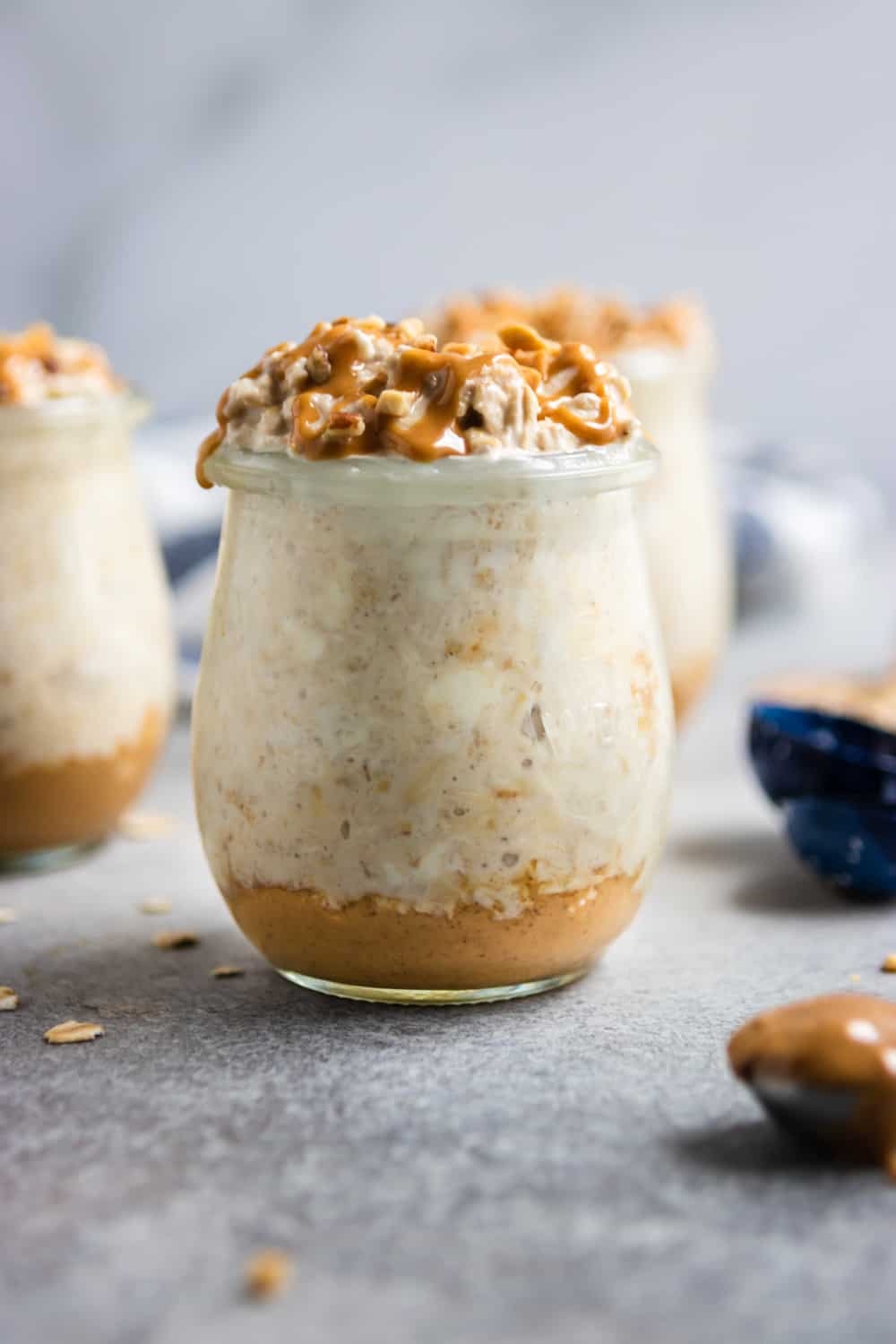 Peanut butter cheesecake overnight Oatmeal in jar with measuring spoons.