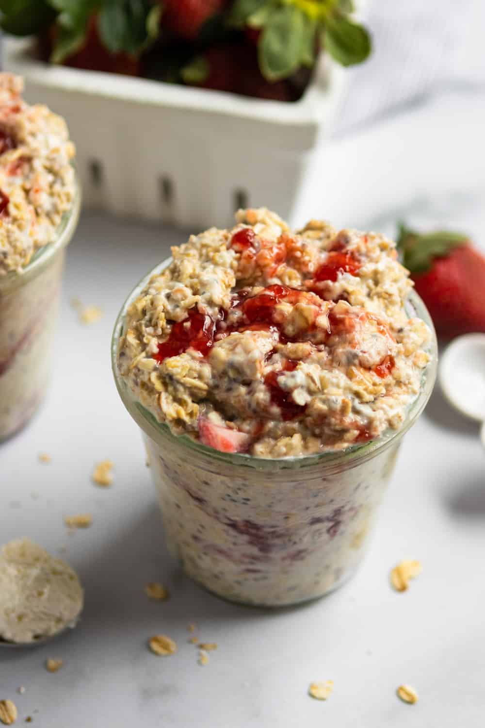 Overnight oatmeal with strawberries and jam in glass jar.
