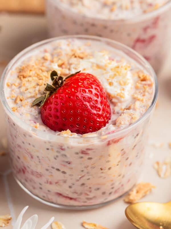 Glass cup with strawberry cheesecake oatmeal with graham crumbs.