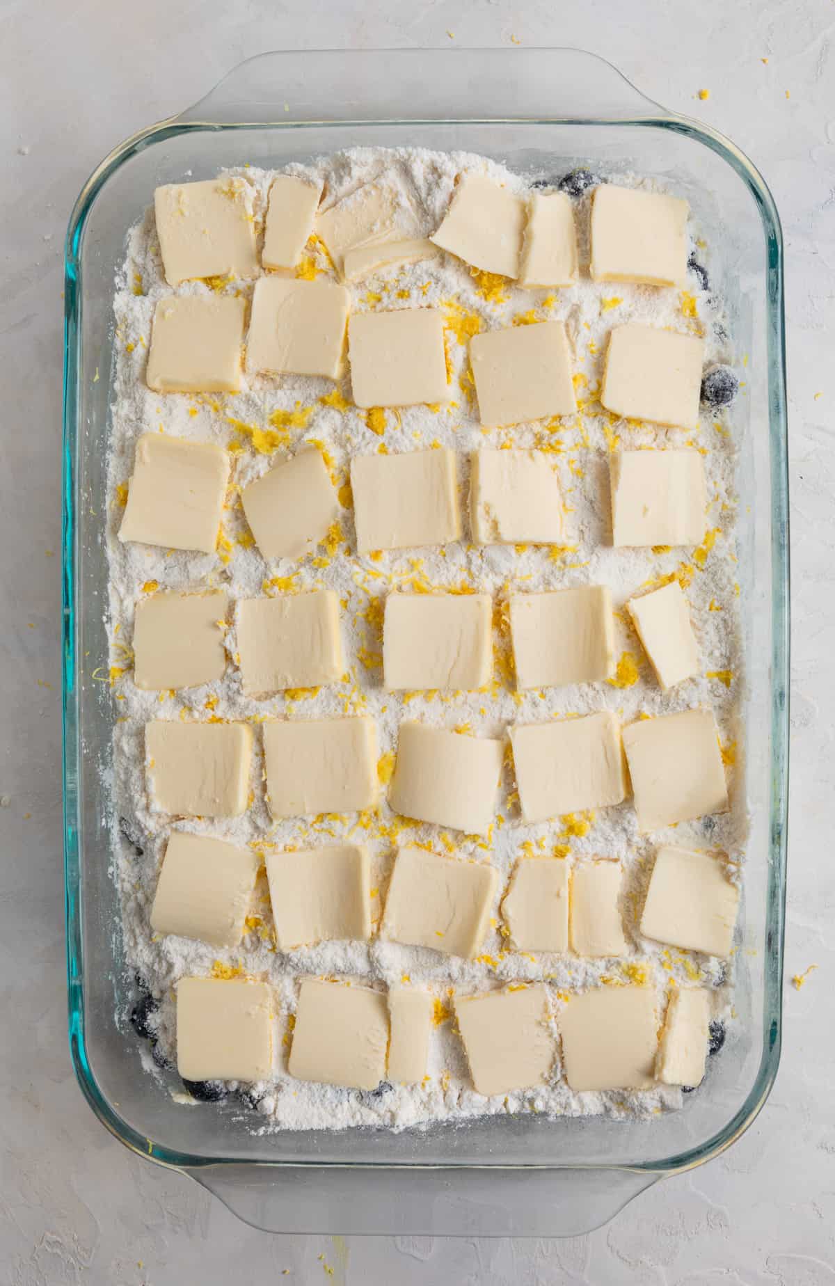 Butter sliced and lined edge to edge of baking pan over cake mix.
