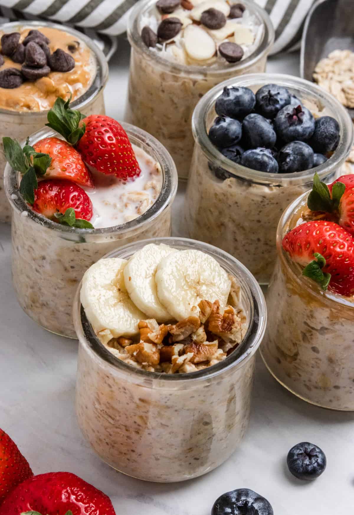 Banana bread oatmeal, strawberry, blueberry and other flavors in glass jars.
