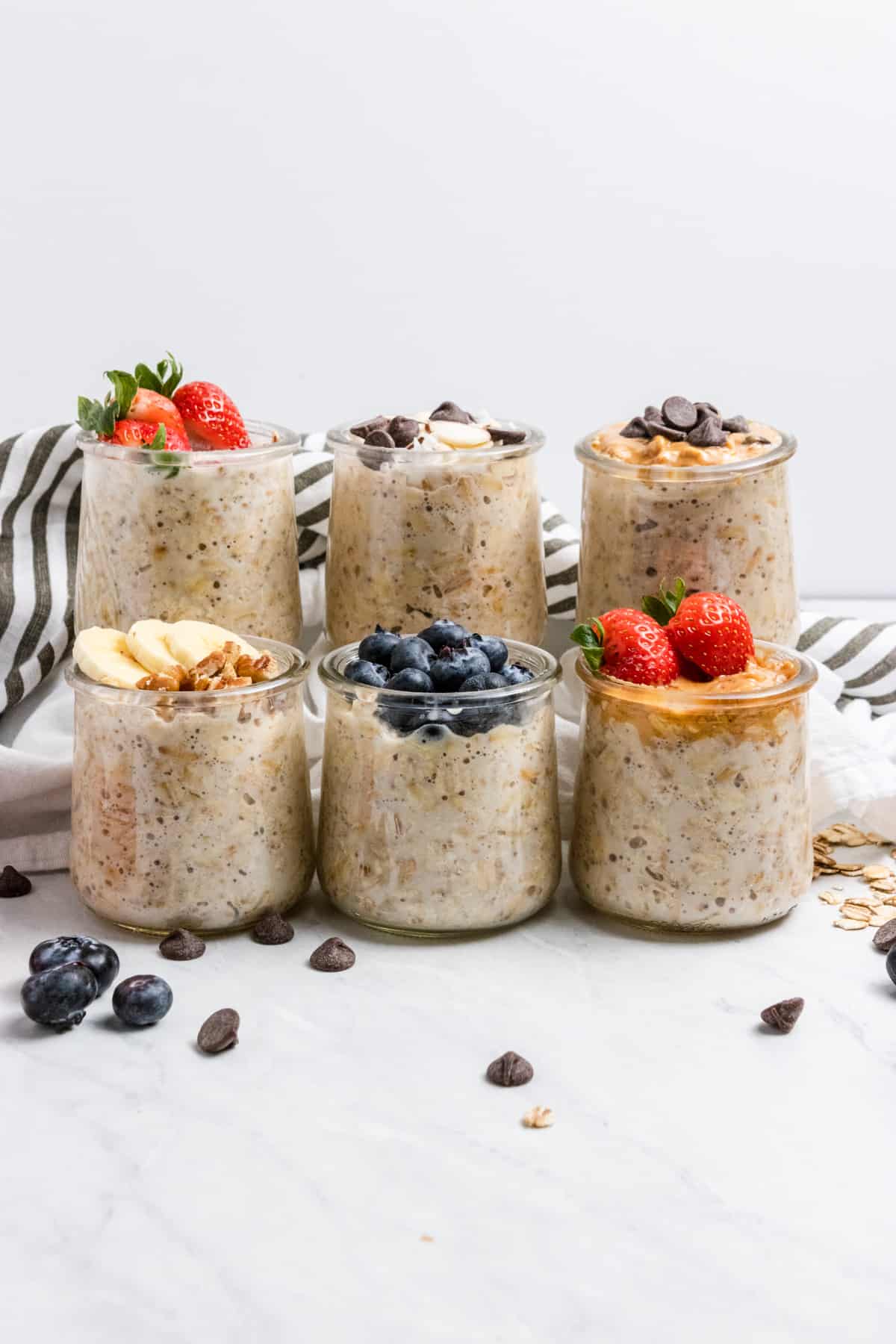 Overnight oats in jars with blueberries, chocolate chips, strawberries, etc.