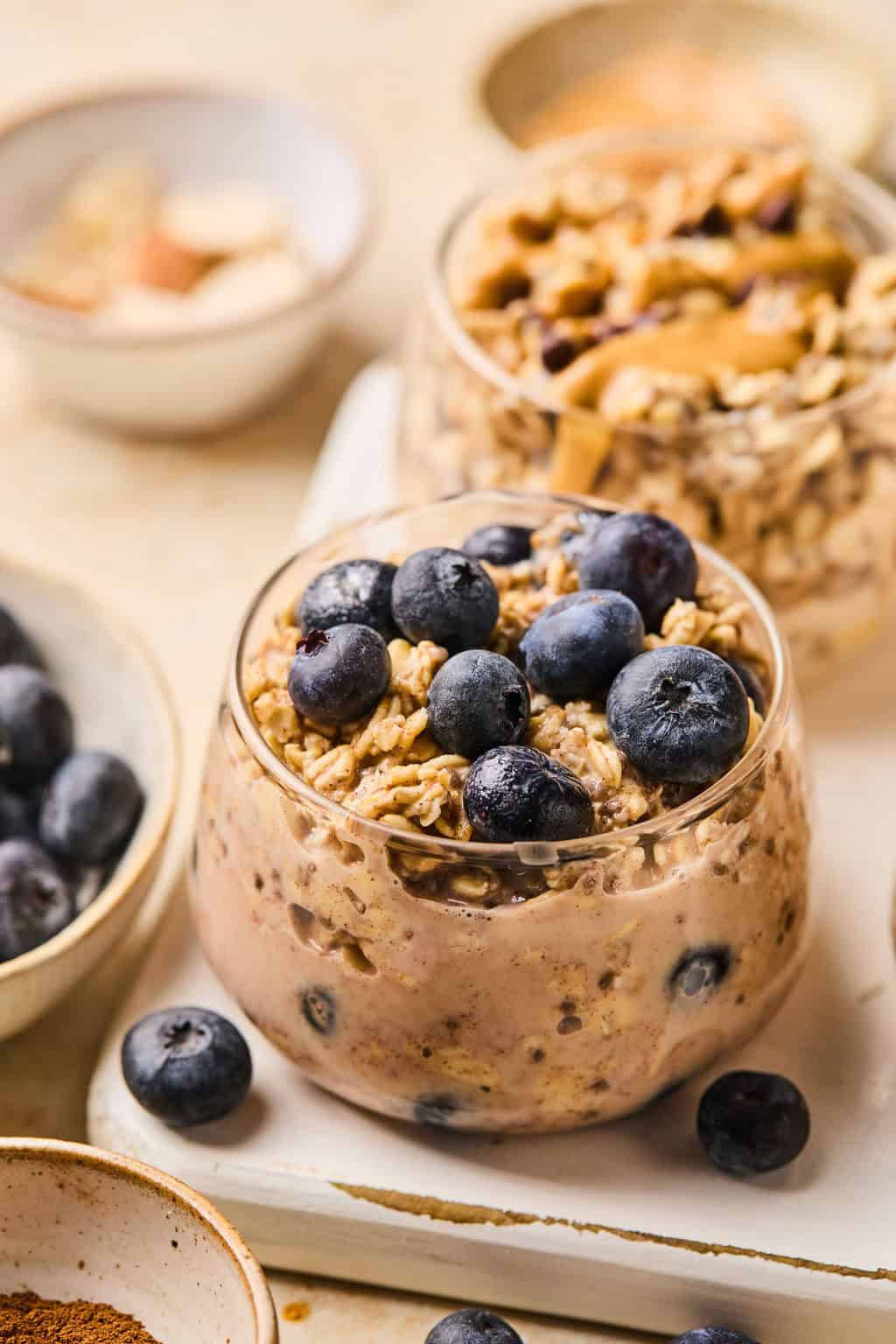 Blueberry muffin oatmeal prepared in glass jar topped with berries.