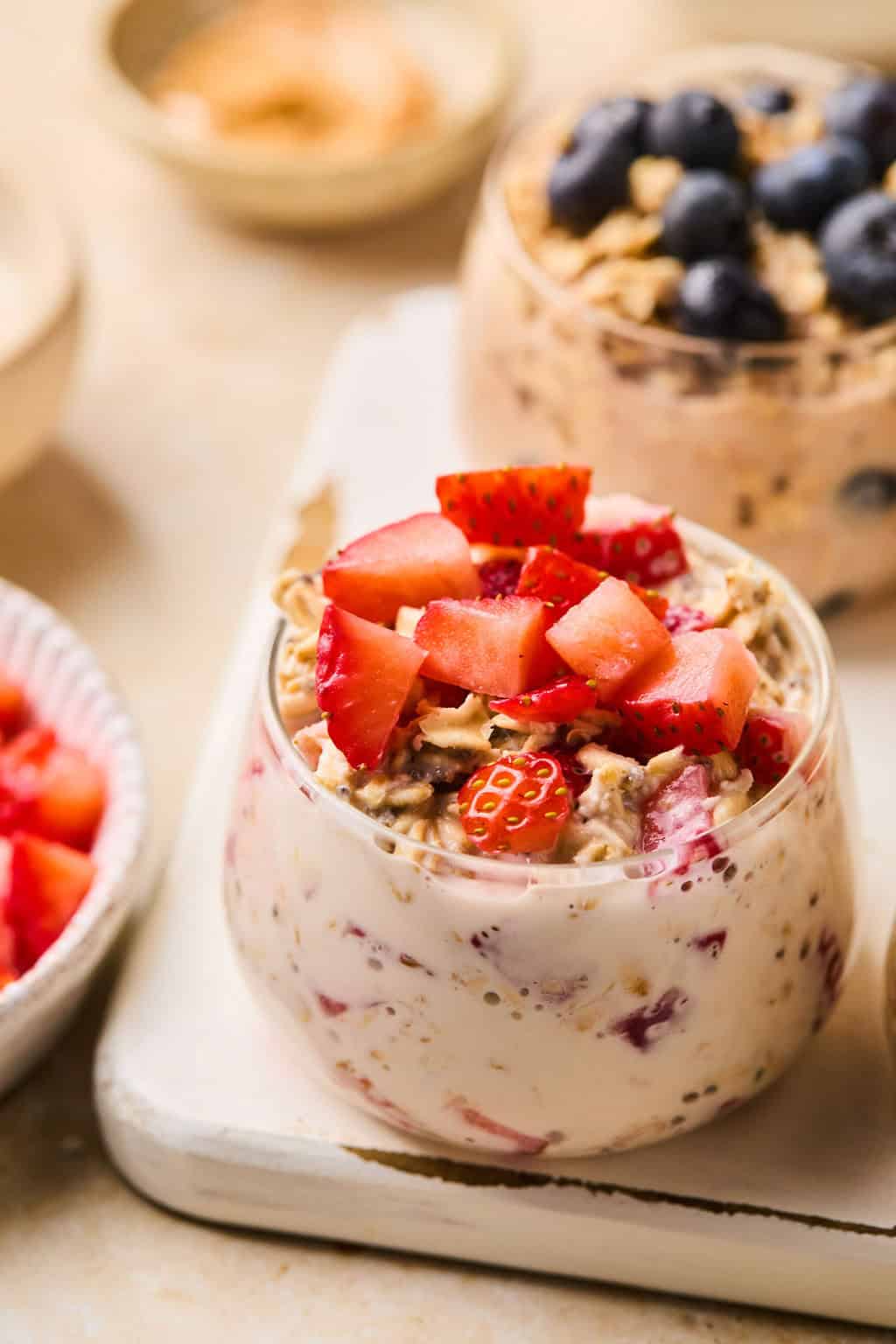 Prepared strawberries and cream oats in bowl with diced strawberries.