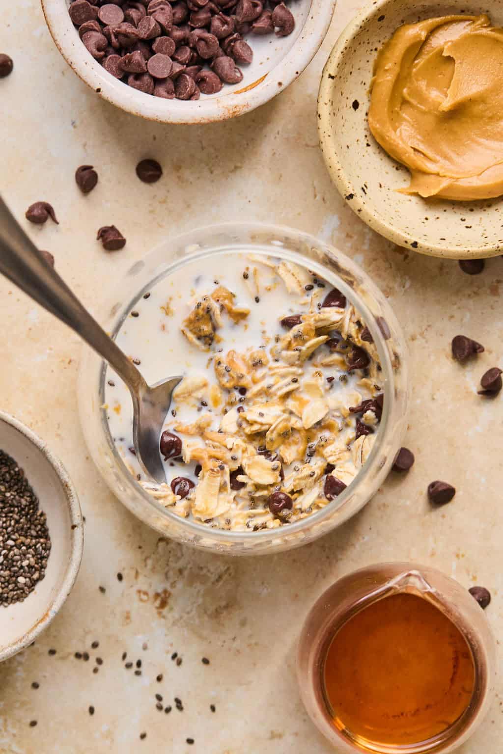 Stirred prepped oats in jar with spoon.
