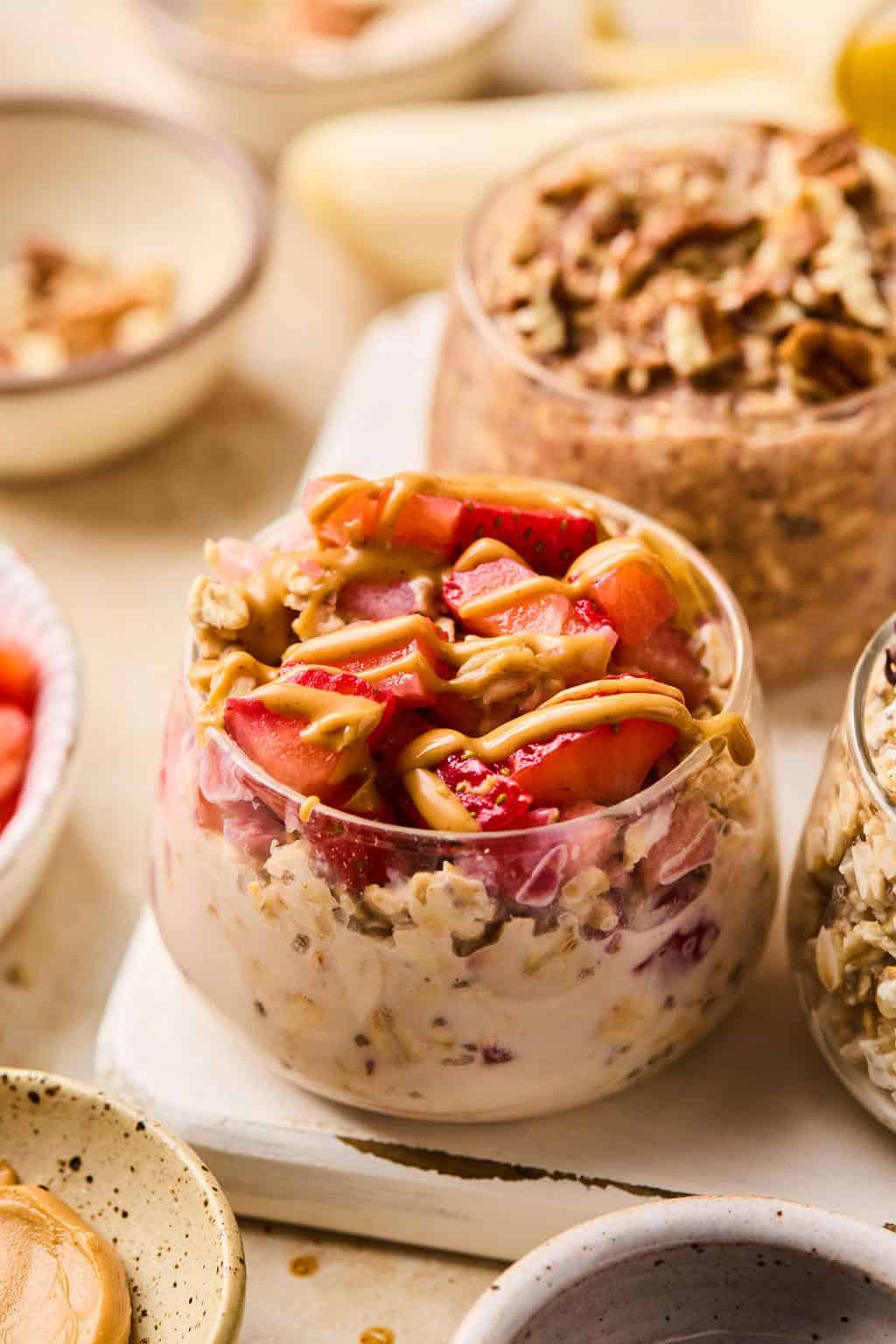 Pb and J oatmeal in dish topped with strawberries and a drizzle of peanut butter.