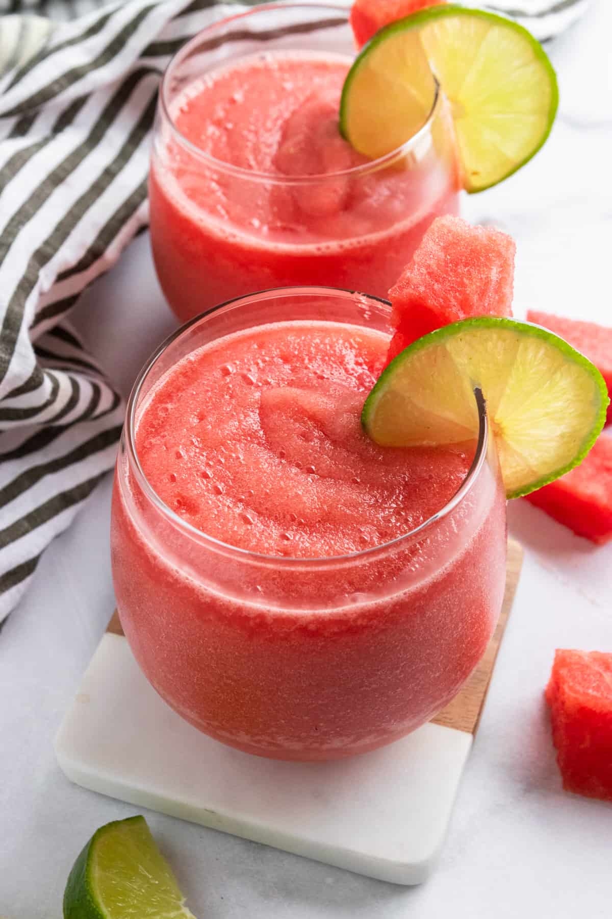 Watermelon frose in glasses with lime slice and watermelon slice.