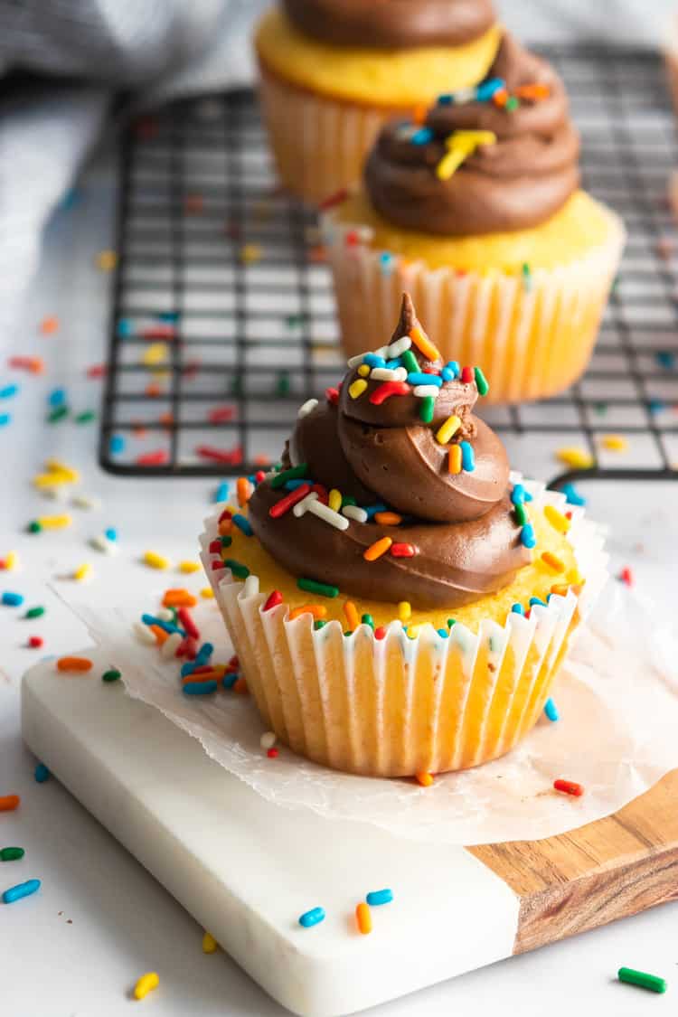 Cupcake on small white and brown platter.