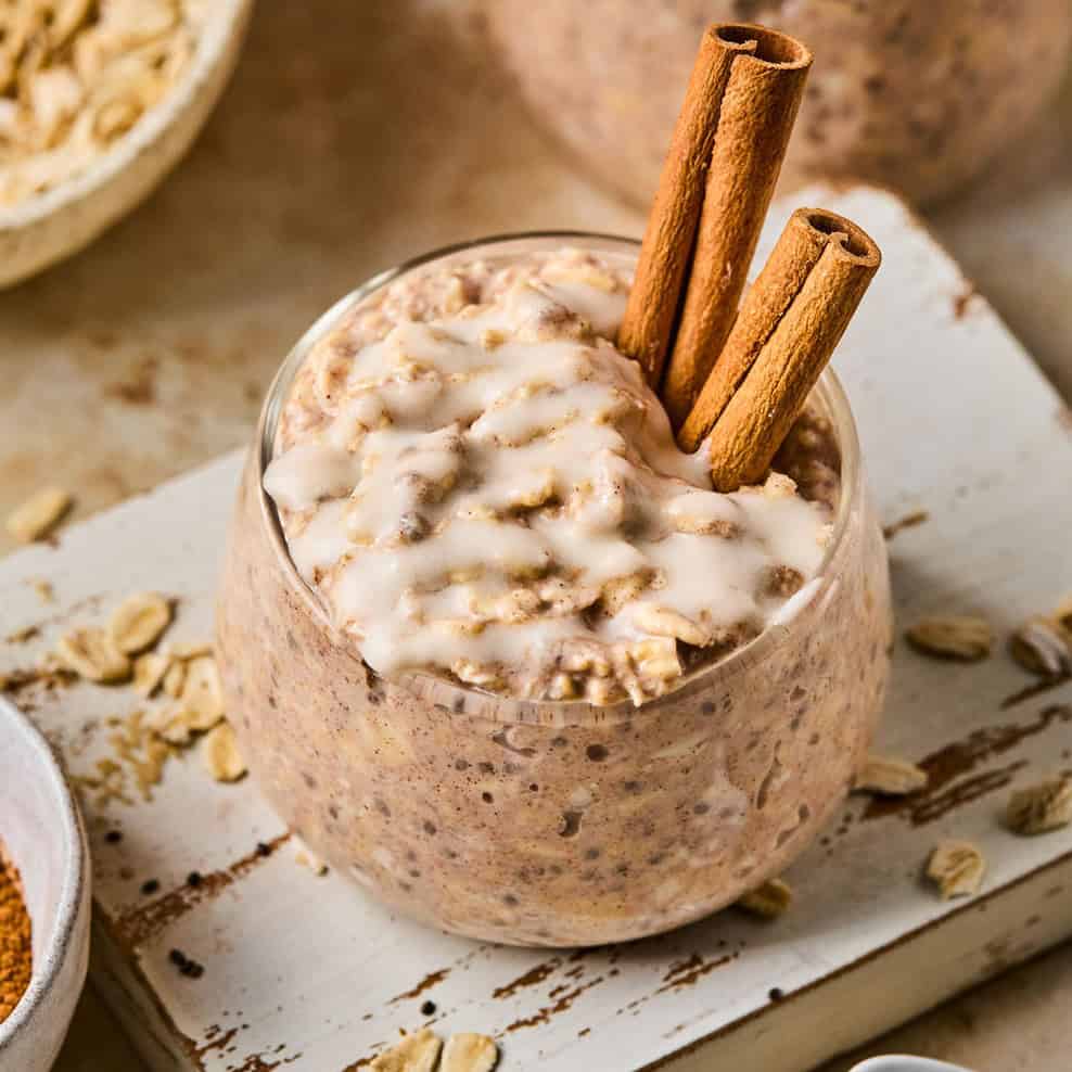 Overnight oats with cinnamon roll flavor in jar with icing drizzled over top.